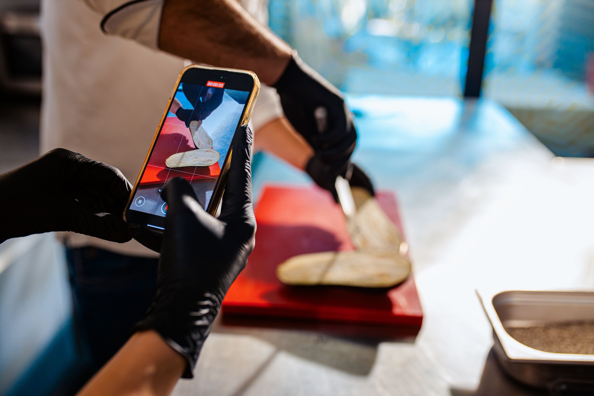 Couple enjoying a cooking class with a chef preparing eggplant for a meal in the kitchen.